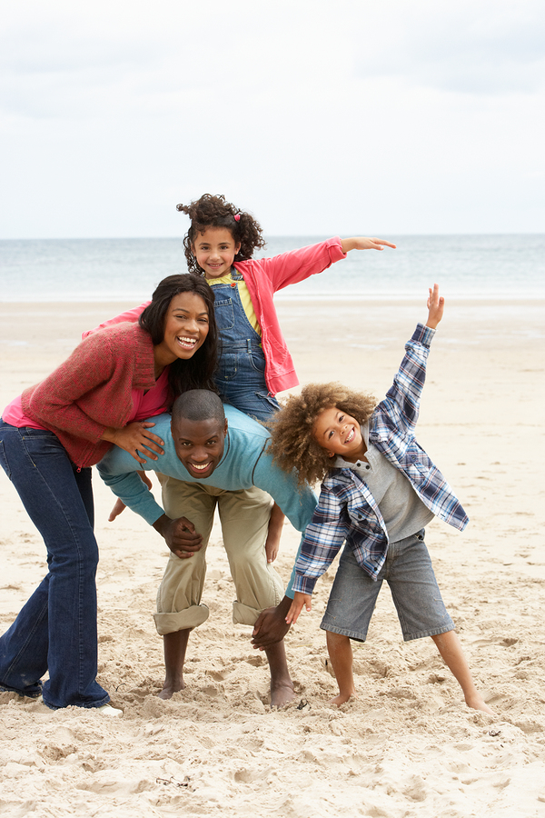 bigstock-Happy-family-playing-on-beach-27386381